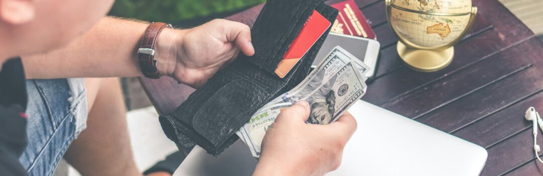 person holding wallet and US dollar bills