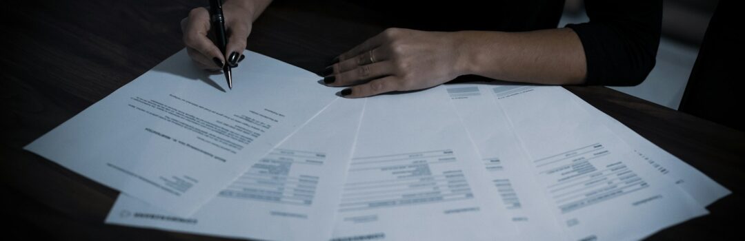 a woman sitting at a table with lots of papers